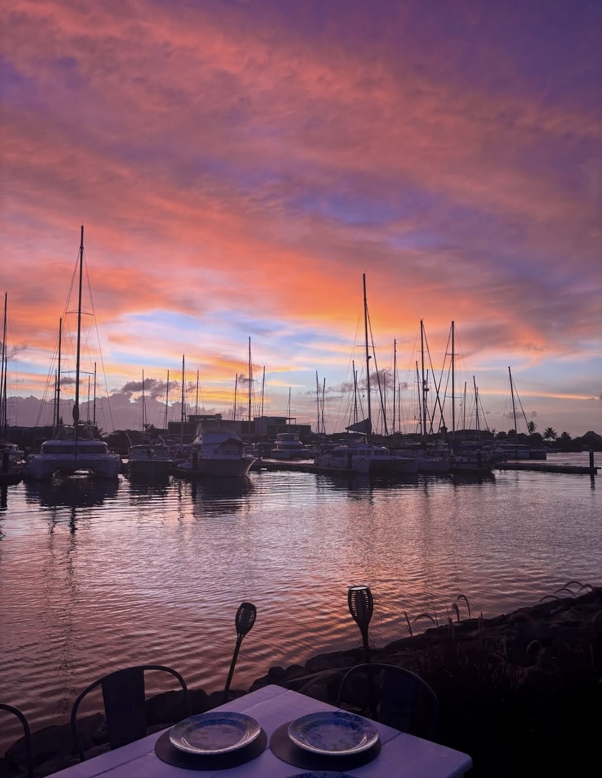 Pink and orange sunset over the yachts of Rodney Bay Marina from a Sea Salt table