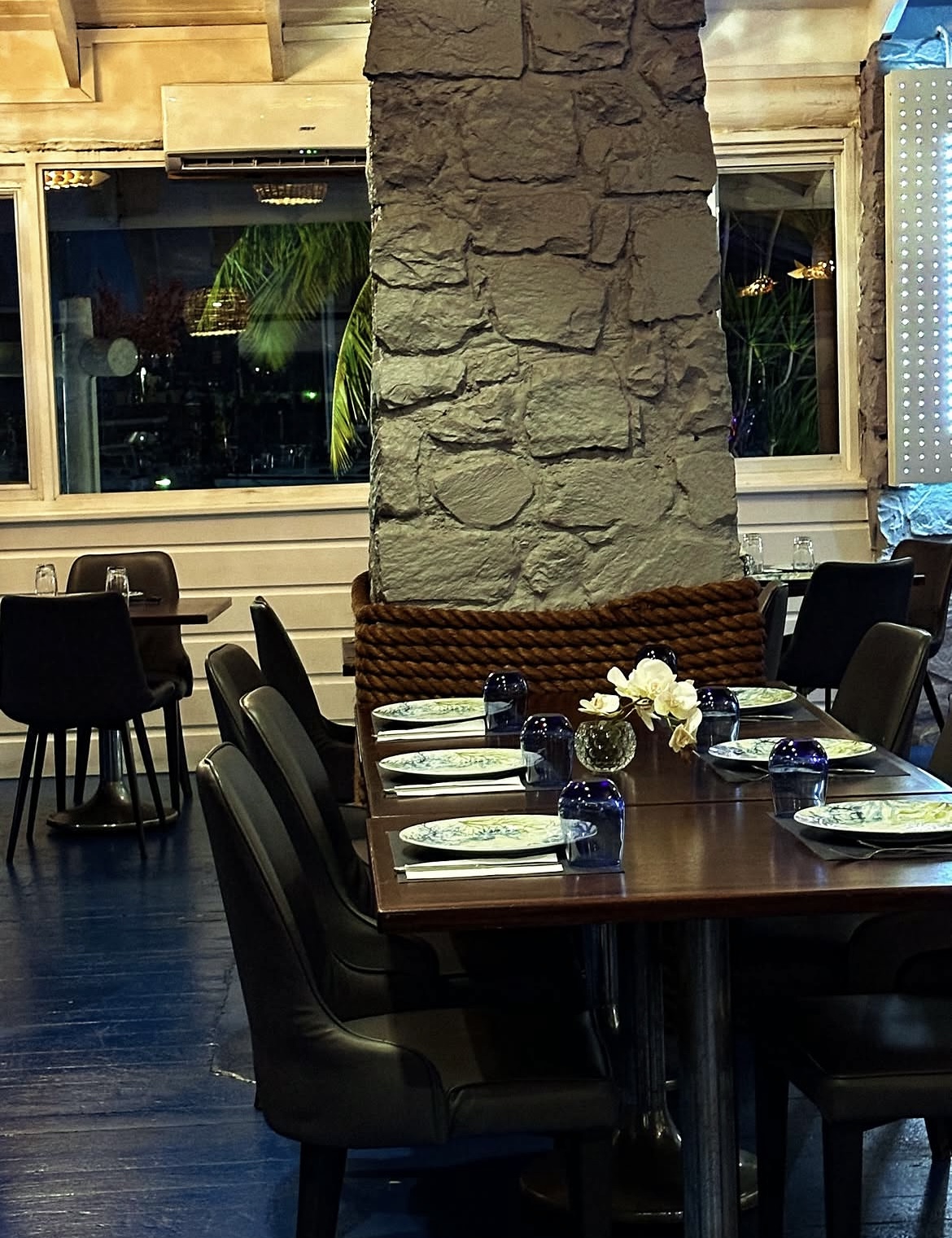 Indoor dining room with stone column, rope detail and set tables