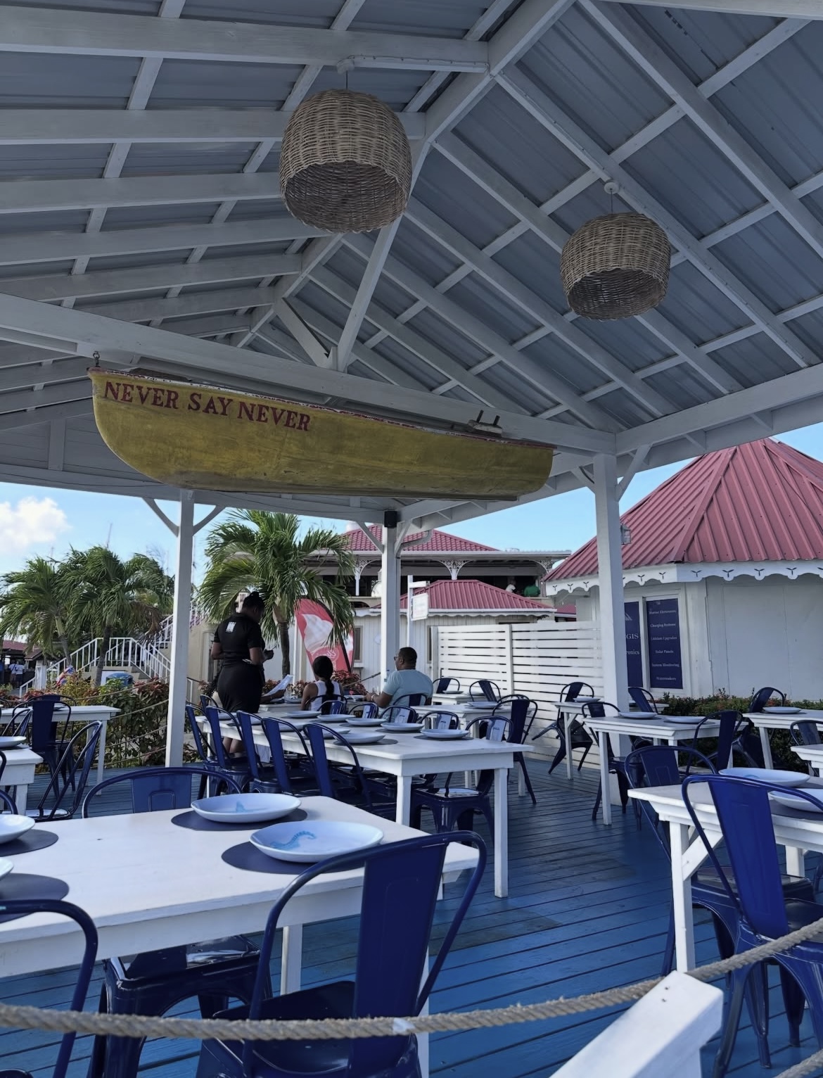 Covered deck with a Never Say Never rowboat overhead and navy chairs